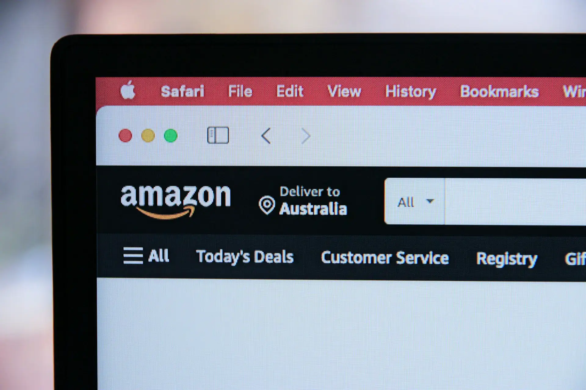 Close-up of a computer screen displaying the Amazon website. The top bar shows menu options like Safari, File, and Edit. The Amazon page header shows options such as All, Todays Deals, and Customer Service, with Deliver to Australia indicated.